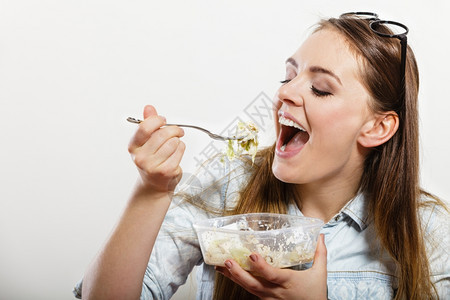 女人吃新鲜蔬菜沙拉快乐的女孩吃健康食物营养图片