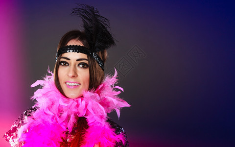 嘉年华时的女反爆狂年轻粉红羽毛和黑头图片