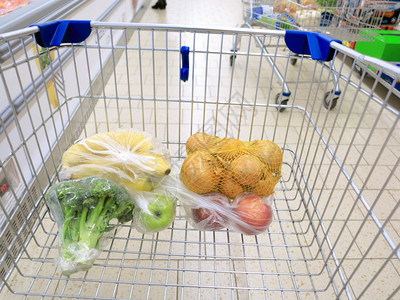 水果蔬菜超市超市装着蔬菜和水果购物手推车背景
