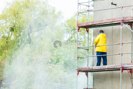 人清洗墙脚手架建筑工地在装修清洁脏物图片