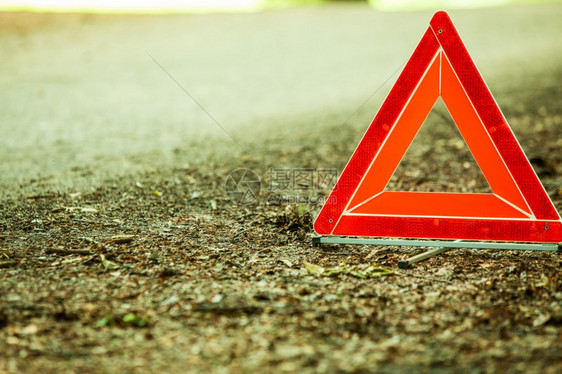 汽车运输转的分布红色警告三角标志的关闭在森林道路上图片