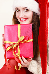 圣诞节冬季幸福概念带着红礼盒戴圣诞帮手帽子的拉廷女人微笑图片