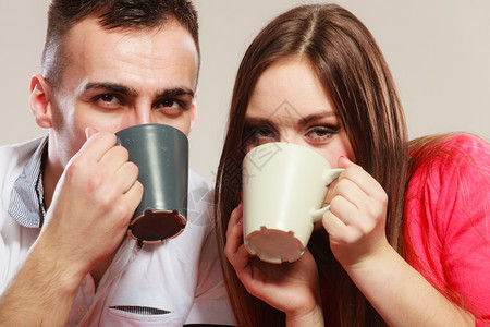 有吸引力的情侣一起喝茶或咖啡男女一起拿着杯子和热饮图片