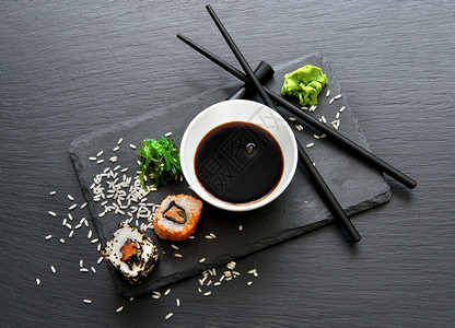 一块桌子上加酱汁和筷的卷图片
