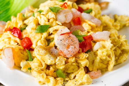 鸡蛋和虾盘选择焦点在前面虾片配有熏肉胡椒和大米图片