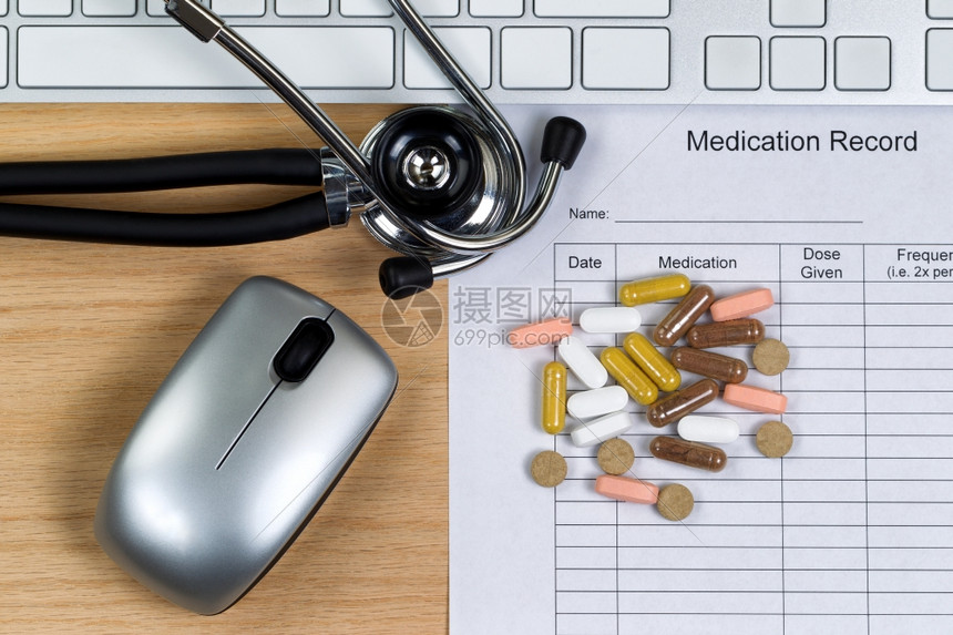 使用听诊器药丸计算机键盘和鼠标的病人药物记录表在木制桌面上使用图片