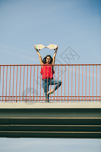 城市滑板女孩酷长发女孩在城市桥上玩滑板活跃的生方式图片