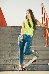 酷滑冰的长发少女在城市楼梯上玩滑板活跃的生方式在夏天很怪异外出运动潮流的青少年图片