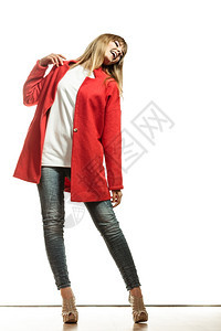 时装身穿鲜红色羊毛大衣高跟鞋的全身着鲜艳红毛衣穿着高跟鞋的金发时装年轻时装女模特背景图片