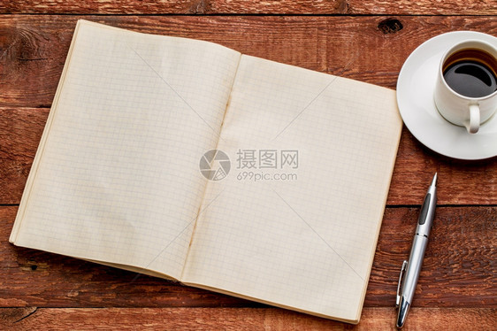 旧的空白笔记本用一杯咖啡打开放在红色谷仓木制桌子上图片