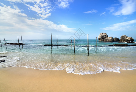 在斯里兰卡印地海滨捕鱼的木电杆背景图片