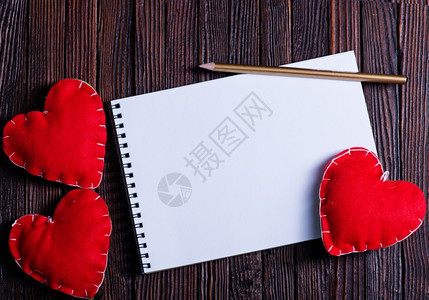 木制桌上的笔记本和红心图片