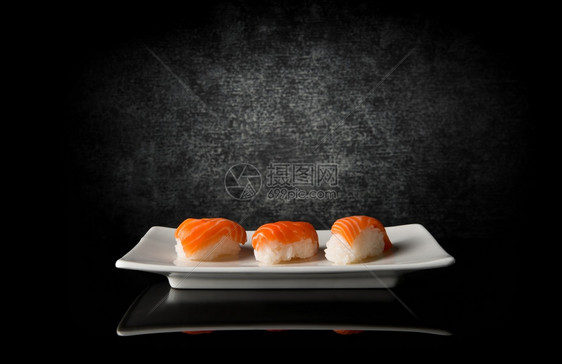 白盘和黑底三片寿司图片