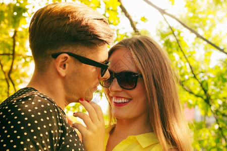快乐的年轻情侣戴着墨镜在公园约会图片