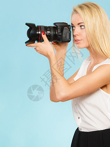 迷人的金发女带着相机拍照灰色背景图片