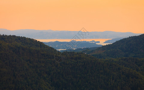 从挪威卑尔根山丘和fjord风景红天日落的全背景图片