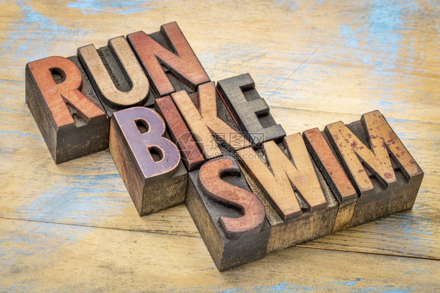 三个thlon概念运行自车和游泳词摘要在老式印刷纸木型机板中图片