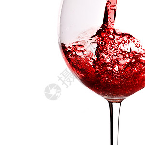 红酒倒入白底面隔绝的玻璃杯中图片
