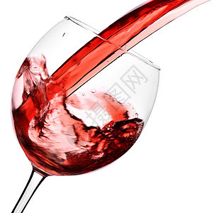 红酒倒入白色背景的玻璃杯中图片