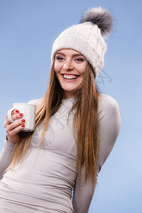 冬冠灰色运动女子滑雪训练时的热内衣拿着杯子喝茶或咖啡图片