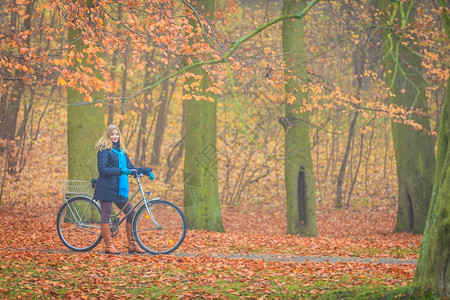 在森林公园骑自行车的妇女停顿休息图片