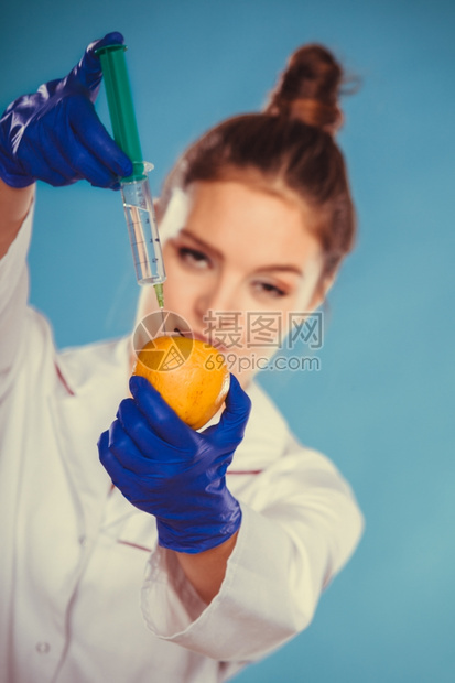 科学家医生注射苹果GM食品科学家医生注射苹果器妇女化学家持有转基因水果GM食品改制图片