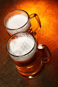 两杯啤酒木制桌上的两杯啤酒图片
