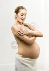 美丽的孕妇在浴室装扮的肖像图片