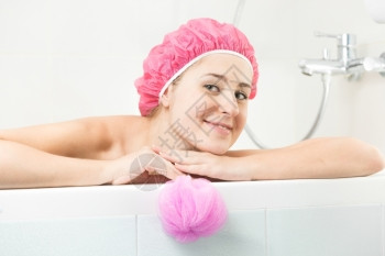 穿着浴帽在洗澡时化妆的淋浴帽年轻女子肖像图片
