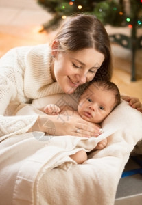 年轻照顾婴儿的母亲与新生婴儿躺在篮子中的婴儿肖像图片