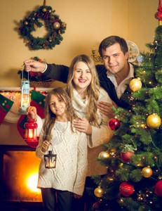 圣诞树上装着灯笼的幸福家庭画像图片