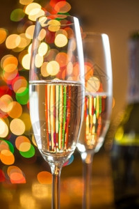 两杯子和香槟对抗闪亮圣诞树的近距离剪贴抽象照片图片