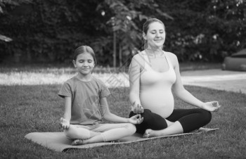 怀孕母亲和女儿在公园冥想的黑白画面图片
