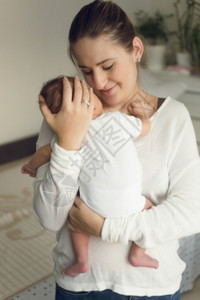 怀着新生男婴的年轻快乐母亲肖像图片