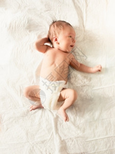 躺在床上白单的尿布中可爱新生婴儿男孩图片