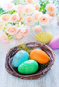 俯视图粉色鲜花和篮子里的彩色鸡蛋图片