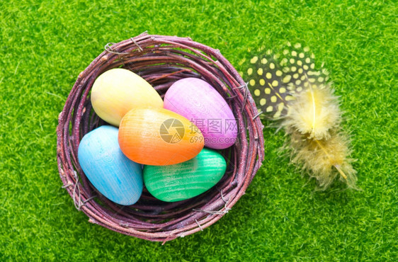 绿草坪上的鸟窝里装满了彩色的鸡蛋图片
