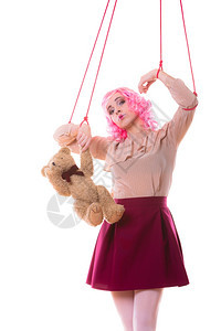 年轻女青孩像木偶般与白色背景孤立的泰迪熊玩具连线图片
