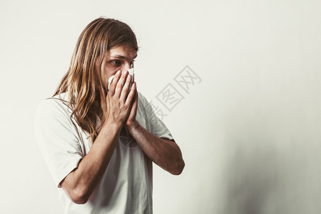 有卫生组织的人过敏和冷感概念长发有卫生组织的年轻病人吹鼻涕的家伙图片