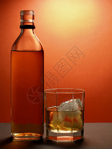 红底酒瓶和威士忌杯图片