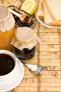 草桌上的咖啡蜂蜜和面包图片
