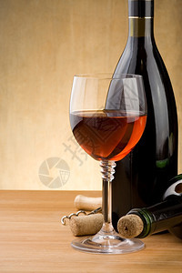 玻璃红酒和瓶木本底有葡萄背景图片