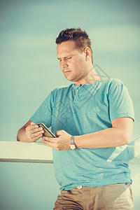 利用智能手机在码头旅游的帅哥时装男享受暑假海上旅行放松和技术概念使用智能手机在码头旅游的人技术图片
