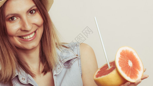 戴帽子的好女人拿着葡萄汁戴草帽的好女人拿着葡萄汁柑橘水果的好女人健康饮食品暑假概念图片