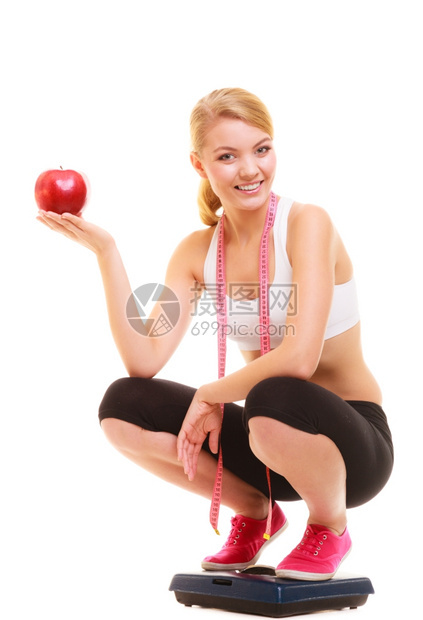快乐的年轻女孩上面有衡量大小的胶带拿着苹果缩小和饮食健康的生活方式营养概念孤立于白种背景图片