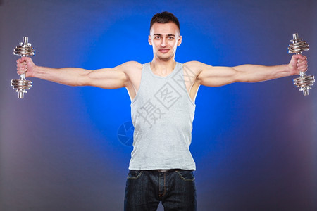 健壮体强的人与哑铃一起锻炼肌肉健壮的年轻人举重深蓝背景图片