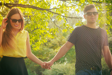 快乐的年轻情侣戴着墨镜在夏日公园露天约会图片