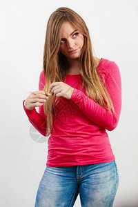 女孩玩她的头发年轻女人拿着头发时装美容的休闲概念图片