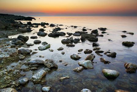 日落时海和岩石自然构成图片