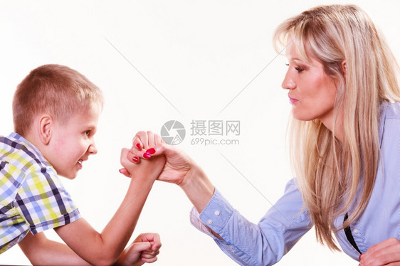 母亲和儿子的手臂摔跤坐在桌子上与家庭乐趣和纽带共度时光母亲和儿子的手臂摔跤在室内玩乐图片
